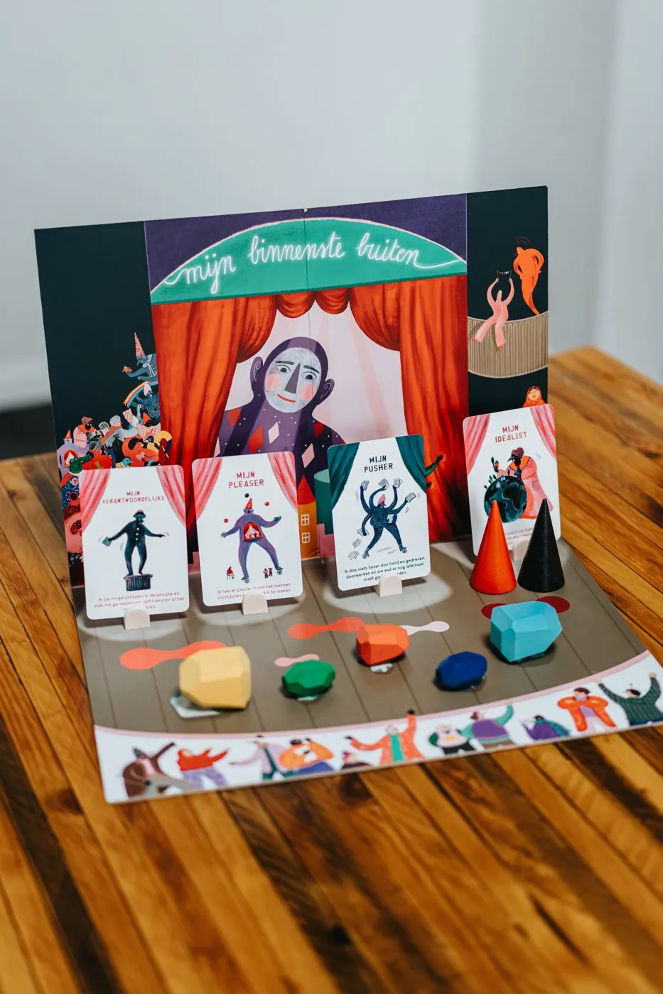 Tafelopstelling met kaarten, kegels en stenen op een houten bord